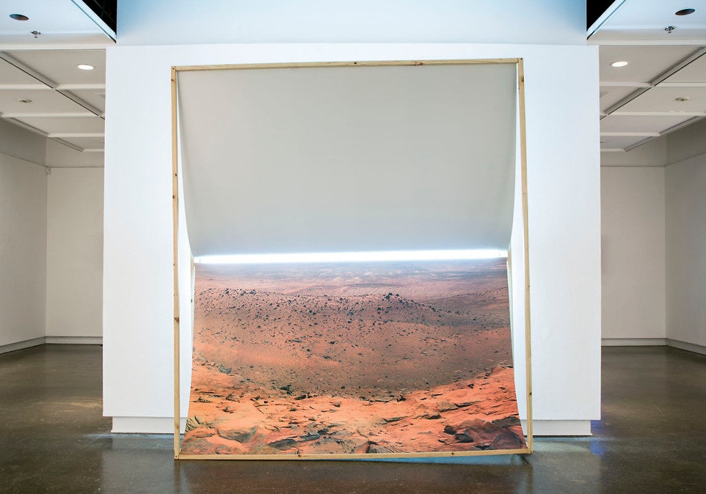Guillermo Gudiño, Infinite Longing,  2013; digital print of NASA image on styrene, wood, fluorescent lamp and rock.