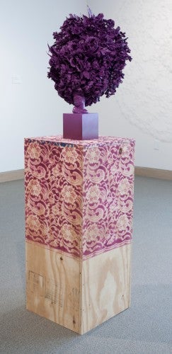 Cherished Tchotchke Knows Her Place (violet), 2014; silk flowers, ceramic vase, wood, concrete block, 65 by 15½ by 15½ inches.