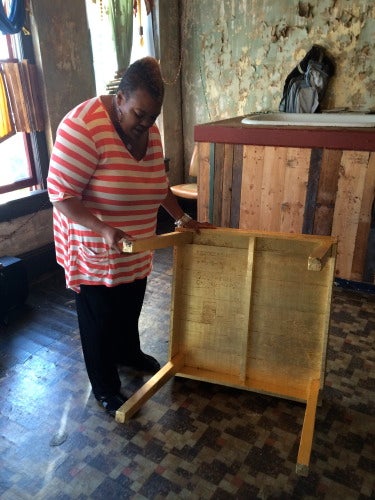 Waddell inspects her piece "Leukerbad" which involved covering a table with gold leaf.