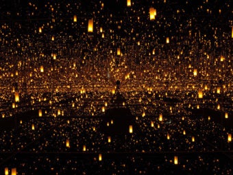 A mirrored room with tiny suspended lights that reflect to 'infinity'
