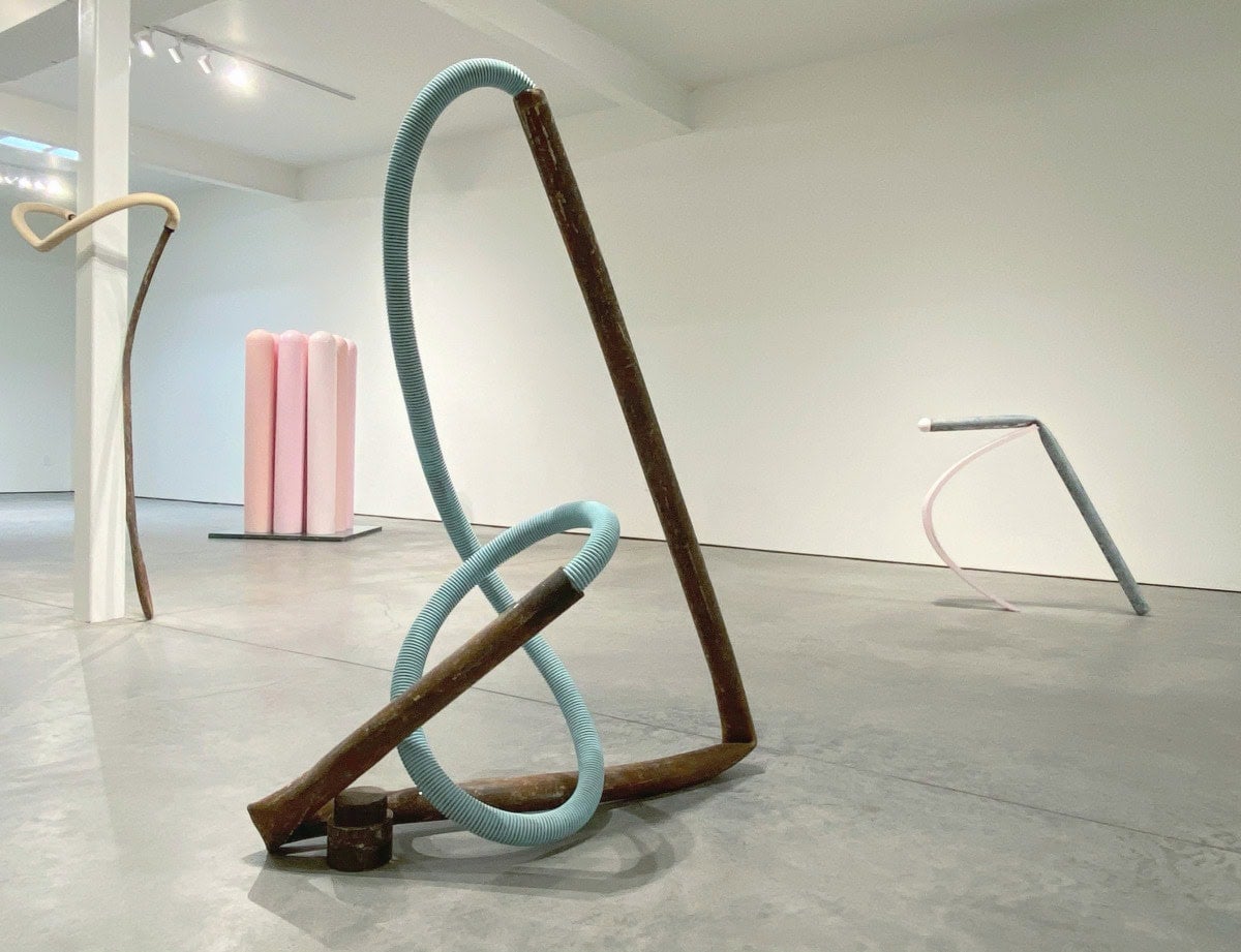 several different colored pipe sculptures on the floor. 