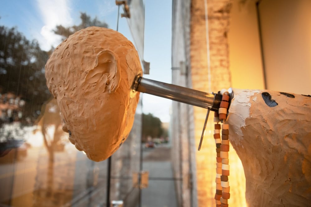 A detailed view of Rose B. Simpson's ceramic sculpture in the street-facing glass display at SCAD Museum of Art in Savannah, Georgia.