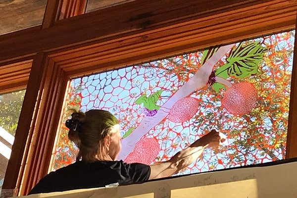 a woman working on a stain glass window
