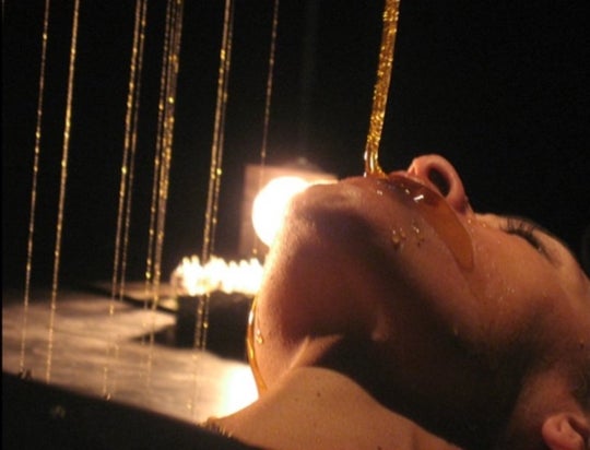 image of a womans face being smeared by a continuous stream of honey