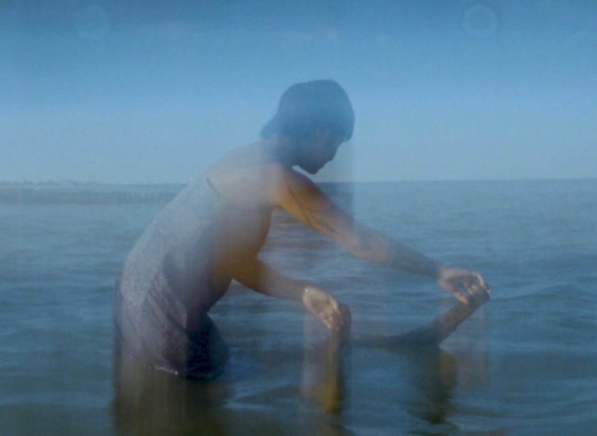 slow captured still of a person with deep blow water, back to the water's horizon