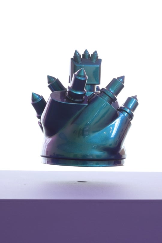 a blue-toned iridescent, metallic sculpture that seemingly floats above a smooth purple cube