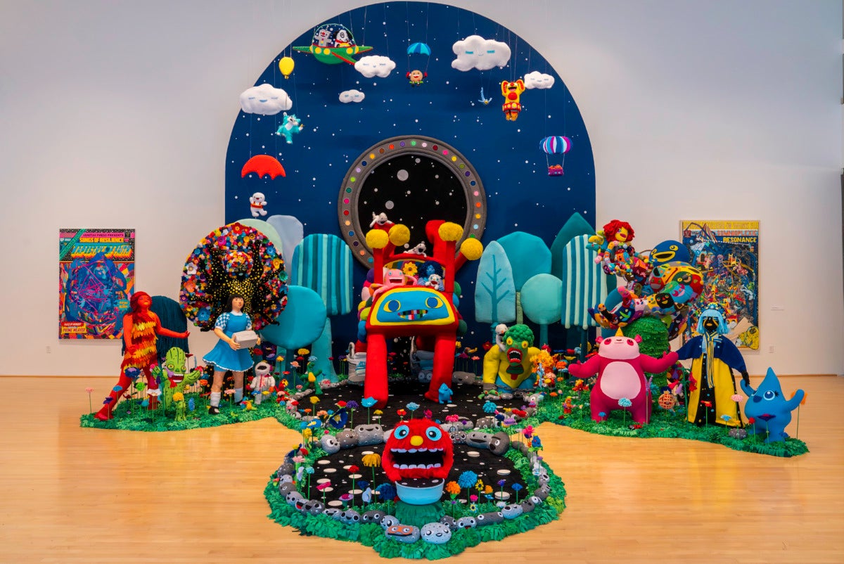 Brightly colored diorama of characters,, plants and curved sky.