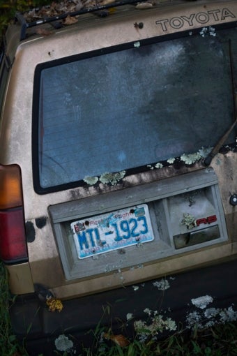 back view of an abandoned Toyota sunken into the ground